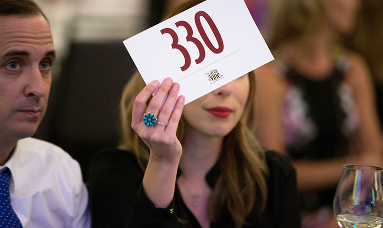 Woman holding auction bid card