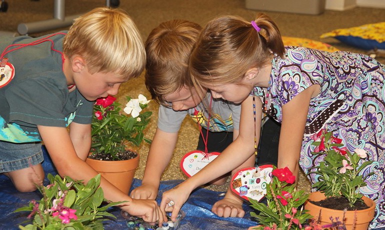 Three children participating in a New Song activity