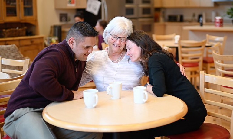 Small group hugging around a table