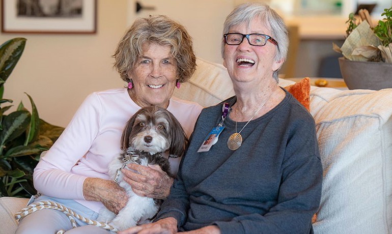 Volunteer Nancy Kelso and small dog Coco Chanel pose with patient Nancy Clark at the DCEC