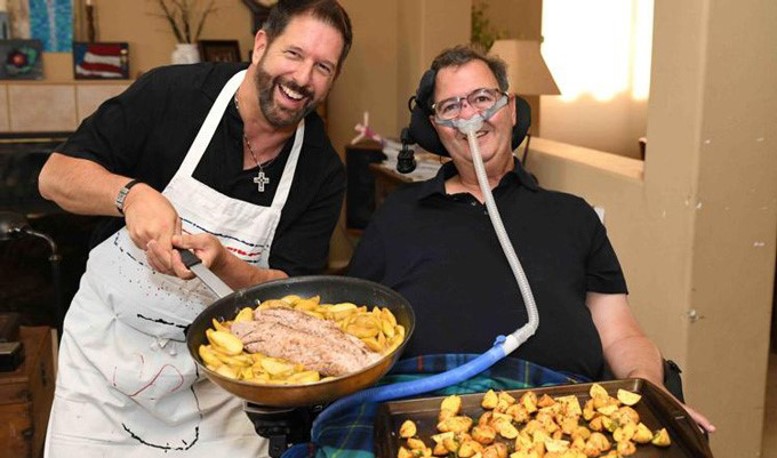 Jeff Riddle and Mark Adinolfi with pan and platter of food