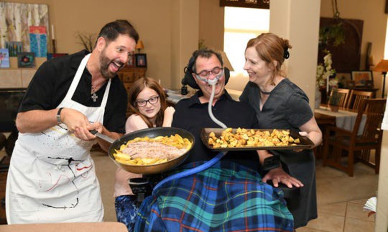 Volunteer Jeff Riddle poses with Mark Adinolfi, his wife Jeane and daughter Sophia and the food they've prepared