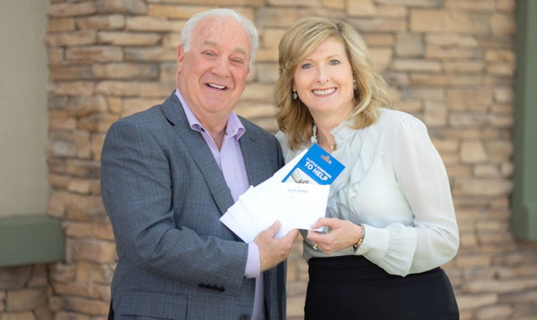 Hospice of the Valley Executive Director Debbie Shumway recognizes Jeff Lewis for his 10,000th grocery gift card donation in seven years. More than 2,000 recipients have been Hospice of the Valley cancer patients.