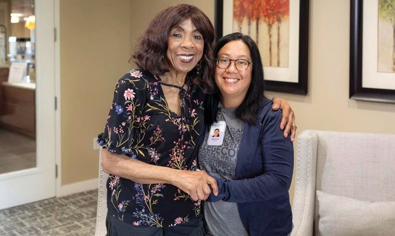 Volunteer Merle Tamondong smiling with HOV patient Micheline