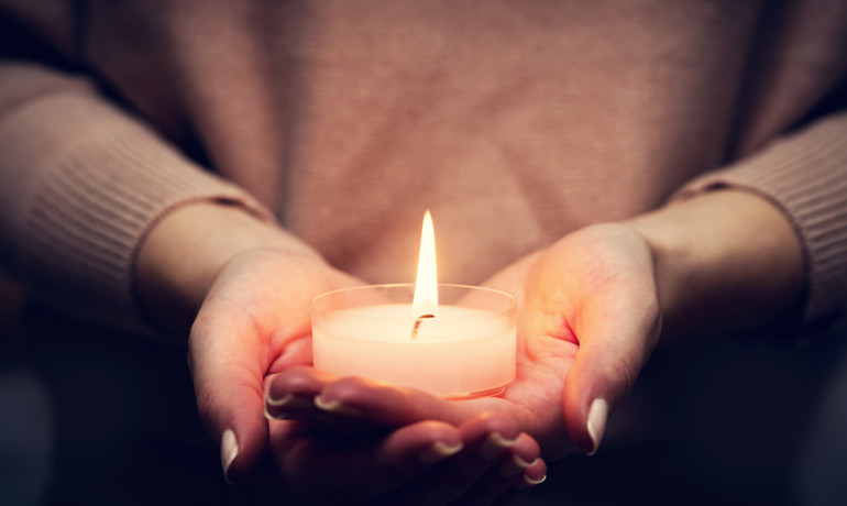 hands holding lit candle