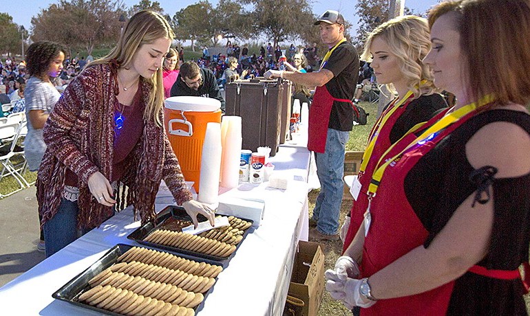 Volunteers handing out cookies at an event